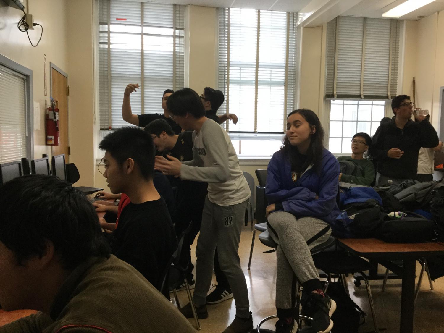 Cheers erupt after a member makes a nice play in League of Legends. Club Officer, Eve Elkouby, sits at a stool, satisfied with the move.