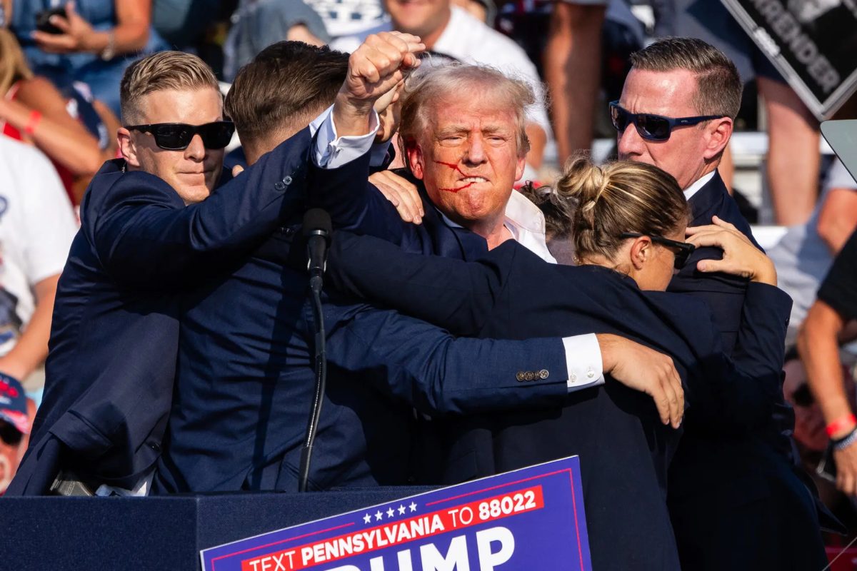 With streaks of blood running along his face, Donald Trump makes a courageous move to show his determination and persistence in the upcoming election (Credit: New York Times). 